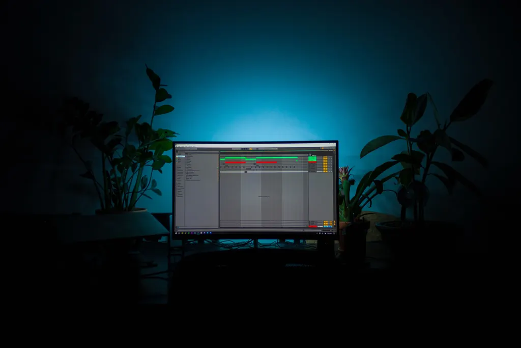 A DAW open on a monitor in a home studio